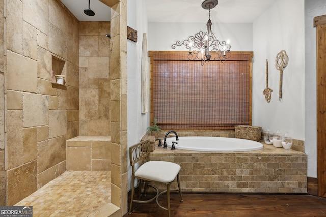 bathroom with hardwood / wood-style flooring, a notable chandelier, and plus walk in shower