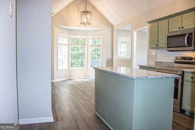 kitchen featuring vaulted ceiling, dark wood-type flooring, pendant lighting, stainless steel appliances, and a textured ceiling