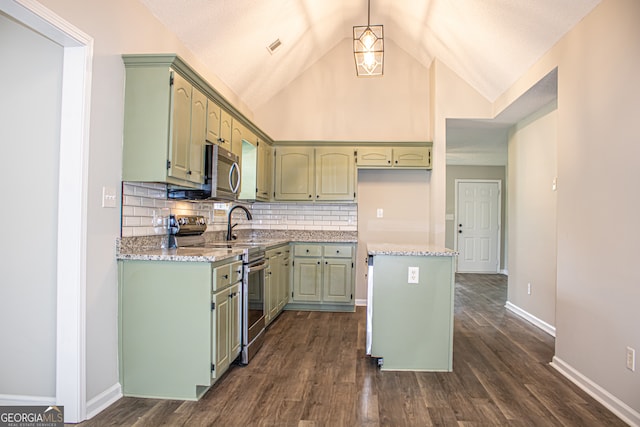 kitchen featuring stainless steel appliances, light stone counters, a center island, and dark hardwood / wood-style floors