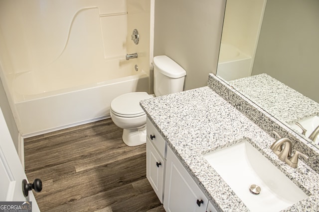 full bathroom with bathtub / shower combination, vanity, hardwood / wood-style floors, and toilet