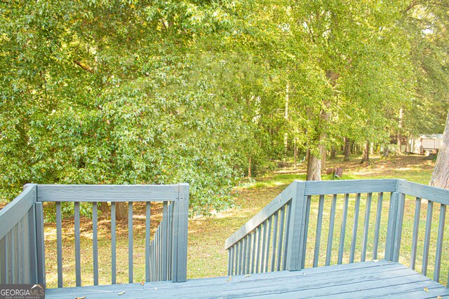 wooden deck featuring a yard