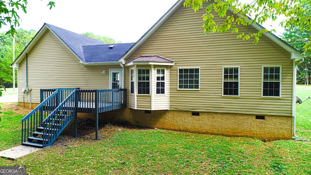 back of house featuring a deck and a yard