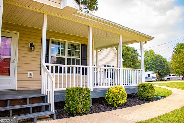 view of exterior entry featuring covered porch