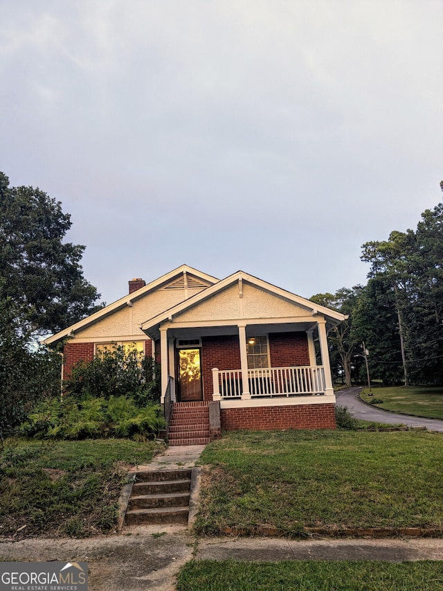 view of front of property featuring a porch and a front lawn