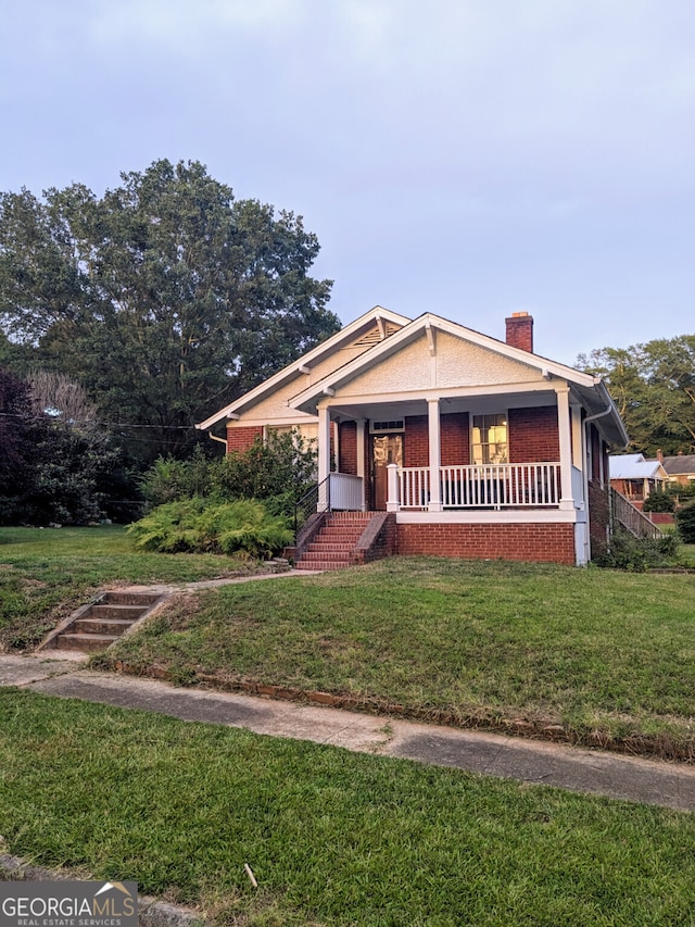 view of front of property featuring a front lawn and covered porch