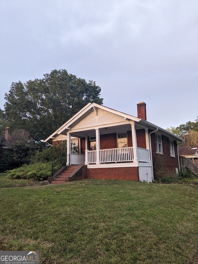 view of front of property with a porch and a front lawn