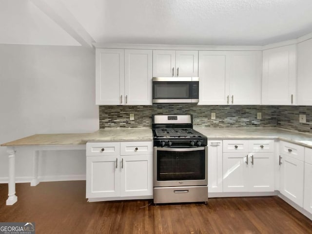 kitchen with white cabinets, stainless steel appliances, backsplash, and dark hardwood / wood-style flooring