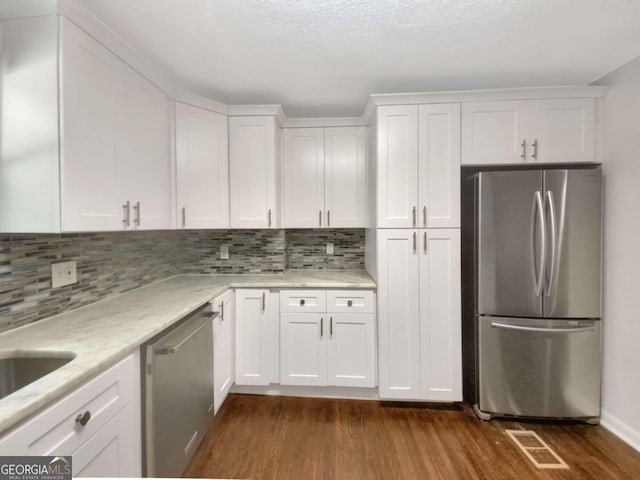 kitchen featuring appliances with stainless steel finishes, dark wood-type flooring, and white cabinetry