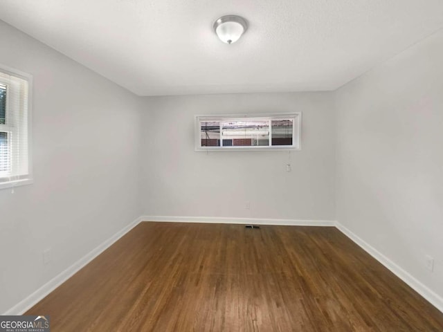 unfurnished room with dark hardwood / wood-style floors