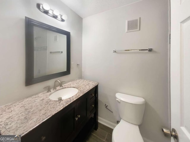 bathroom with vanity, tile patterned flooring, toilet, and a textured ceiling