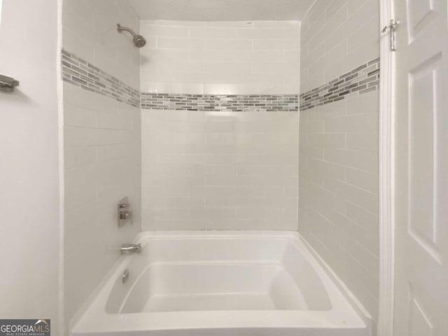 bathroom featuring tiled shower / bath