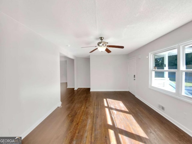 spare room featuring a textured ceiling, dark hardwood / wood-style floors, and ceiling fan