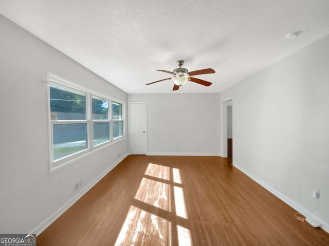 unfurnished room featuring a textured ceiling, wood-type flooring, and ceiling fan