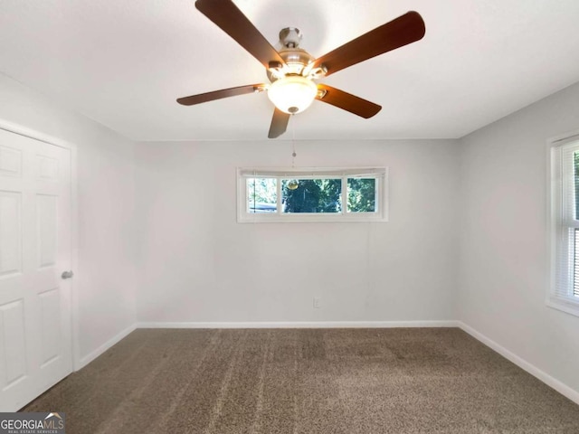 unfurnished room with ceiling fan, carpet flooring, and a wealth of natural light