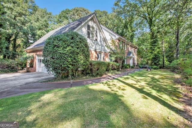 view of side of home with a garage and a lawn