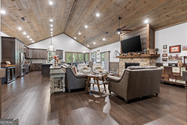 living room featuring ceiling fan, a stone fireplace, high vaulted ceiling, dark hardwood / wood-style floors, and wooden ceiling