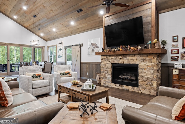 living room with wood ceiling, a fireplace, a barn door, high vaulted ceiling, and ceiling fan