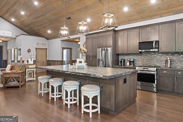 kitchen featuring stainless steel appliances, hanging light fixtures, dark hardwood / wood-style flooring, and a center island