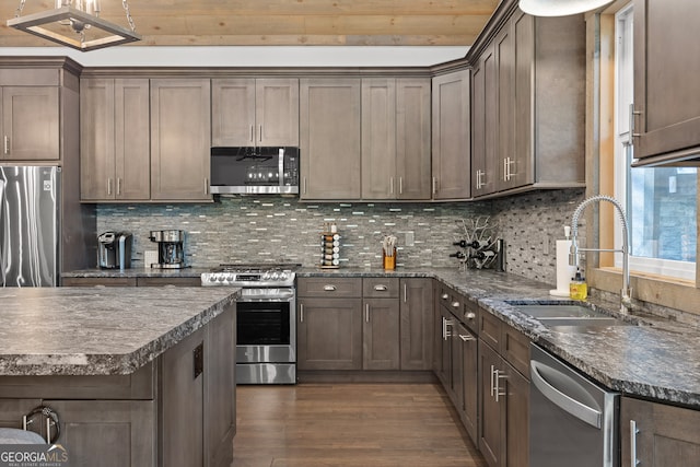 kitchen featuring sink, dark wood-type flooring, stainless steel appliances, and tasteful backsplash