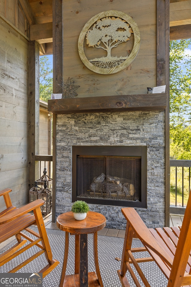 interior space with wood-type flooring, a stone fireplace, and wooden walls