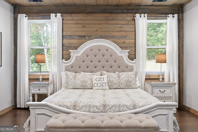 bedroom with wood ceiling, wood walls, multiple windows, and dark wood-type flooring