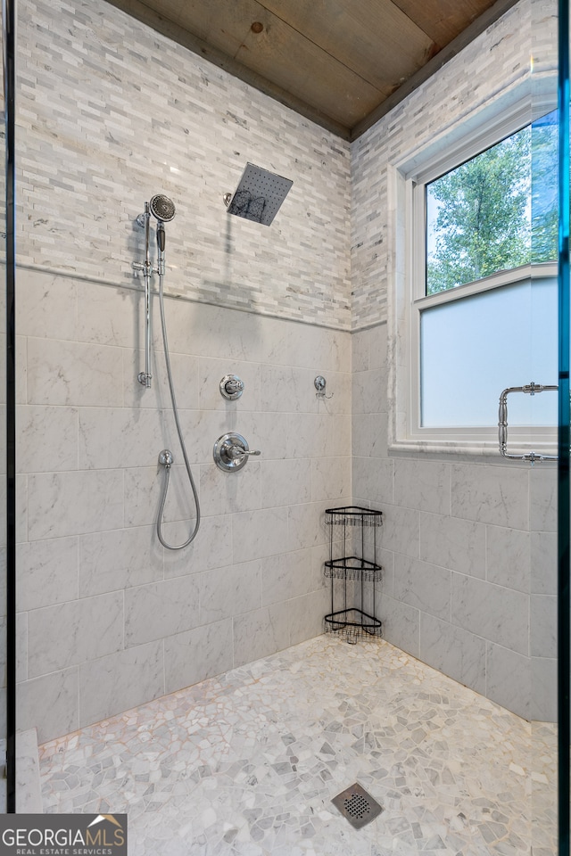 bathroom with wood ceiling and tiled shower