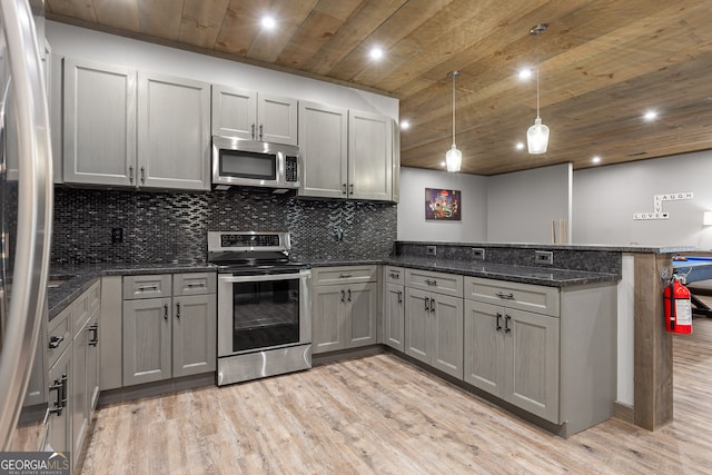 kitchen with gray cabinetry, stainless steel appliances, and light hardwood / wood-style floors