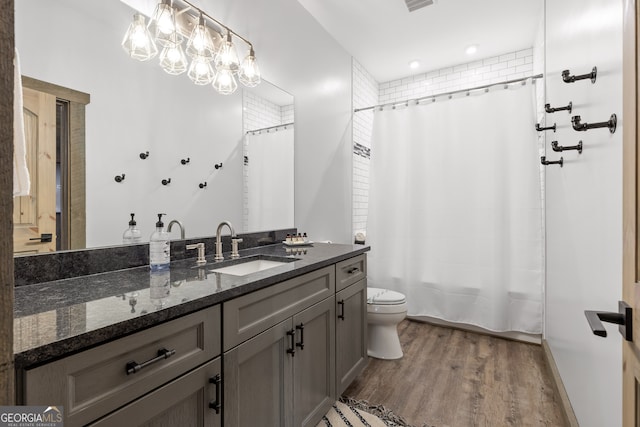 bathroom featuring vanity, hardwood / wood-style floors, toilet, and a chandelier