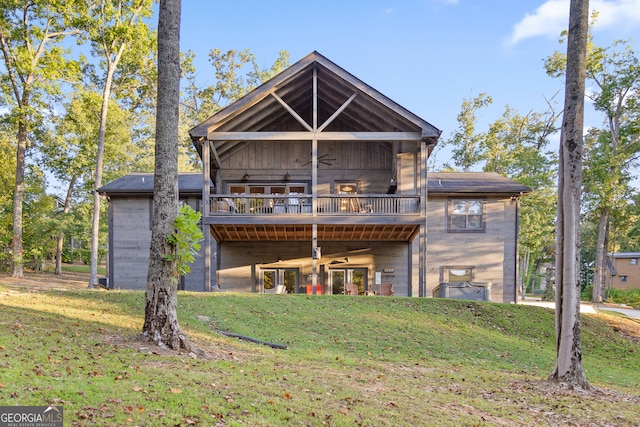 back of house featuring a wooden deck and a yard