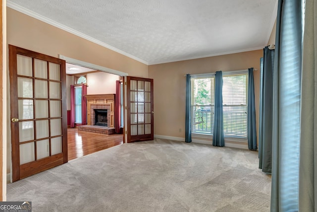 unfurnished living room with light colored carpet, a textured ceiling, a fireplace, and ornamental molding