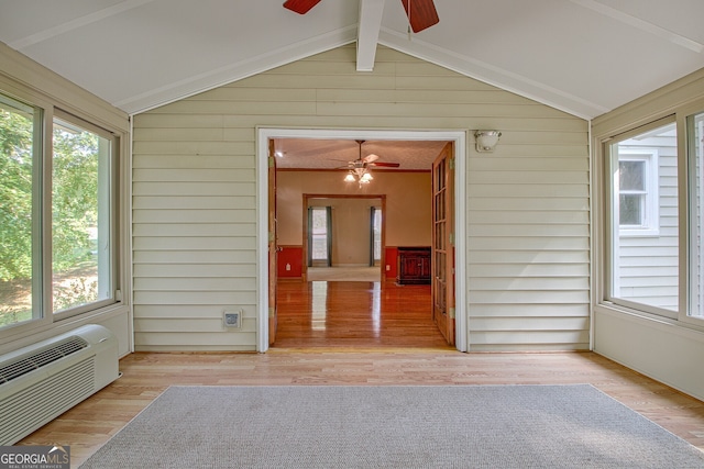 unfurnished sunroom featuring ceiling fan, lofted ceiling with beams, and a wealth of natural light