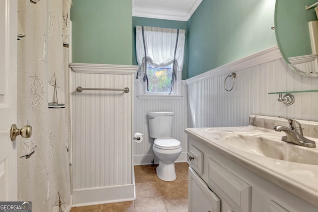 bathroom with vanity, toilet, ornamental molding, walk in shower, and tile patterned flooring