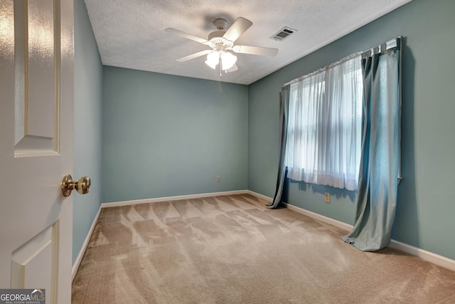 carpeted empty room with a textured ceiling and ceiling fan