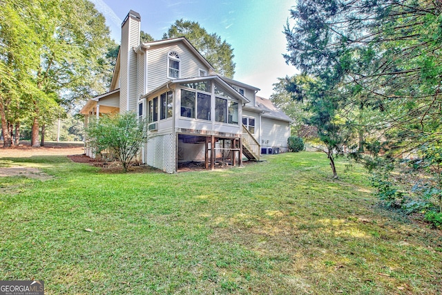 back of house with a sunroom and a yard