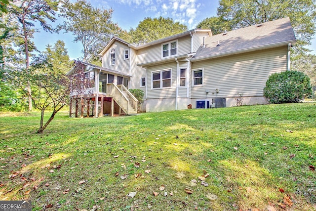 rear view of house featuring central AC unit and a yard