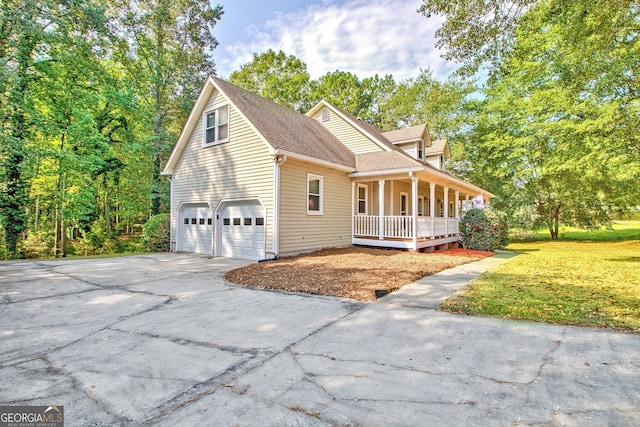 front of property featuring a front lawn, covered porch, and a garage