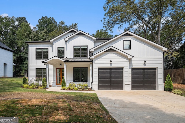 modern farmhouse featuring a front yard and a garage