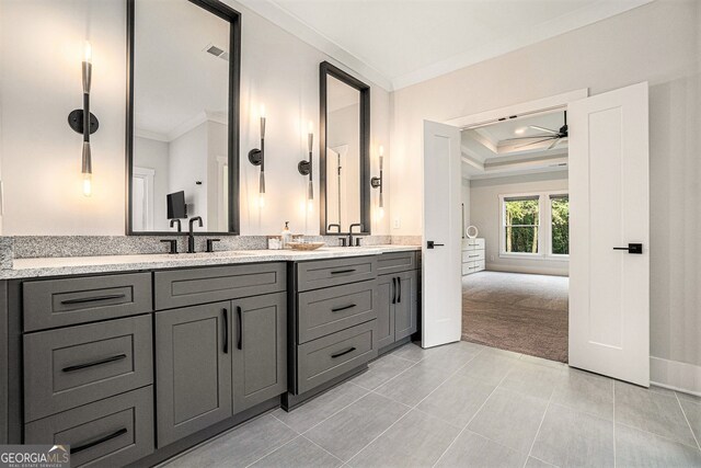 bathroom featuring tile patterned flooring, ceiling fan, a raised ceiling, ornamental molding, and vanity