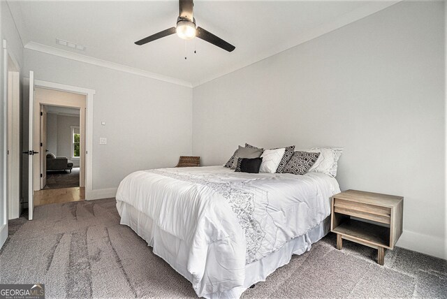 carpeted bedroom featuring ceiling fan and crown molding