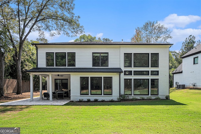 back of house featuring central air condition unit, a patio, and a yard