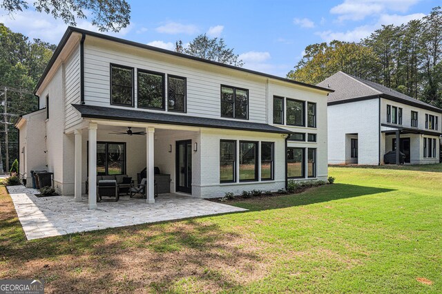 rear view of property featuring ceiling fan, an outdoor hangout area, a yard, and a patio