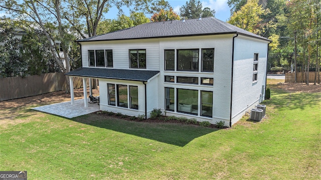 rear view of house with a yard, a patio, and central AC unit