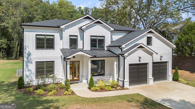 modern inspired farmhouse with a front lawn, central AC unit, and a garage