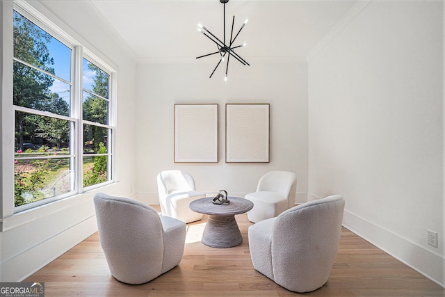 living area with a wealth of natural light, an inviting chandelier, and wood-type flooring