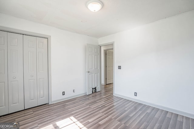 unfurnished bedroom featuring a closet and light hardwood / wood-style floors