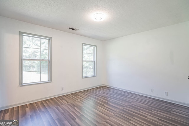 unfurnished room featuring a textured ceiling and dark wood-type flooring