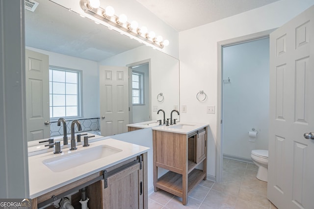 bathroom featuring a textured ceiling, tile patterned flooring, vanity, and toilet