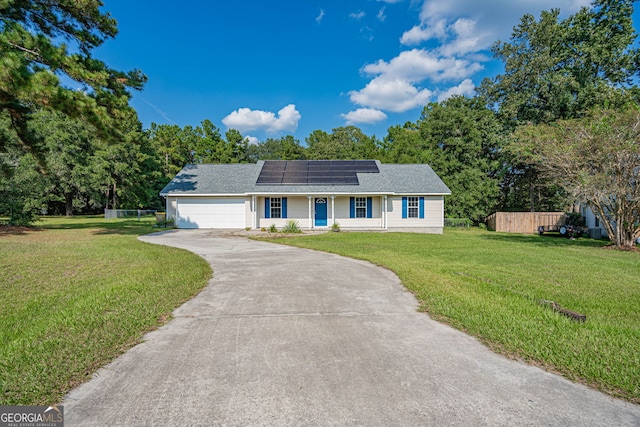 ranch-style house with a front yard, a garage, and solar panels