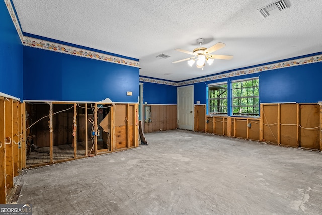 empty room with ceiling fan and a textured ceiling