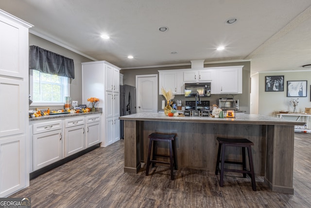 kitchen featuring dark wood-type flooring, white cabinetry, and black appliances